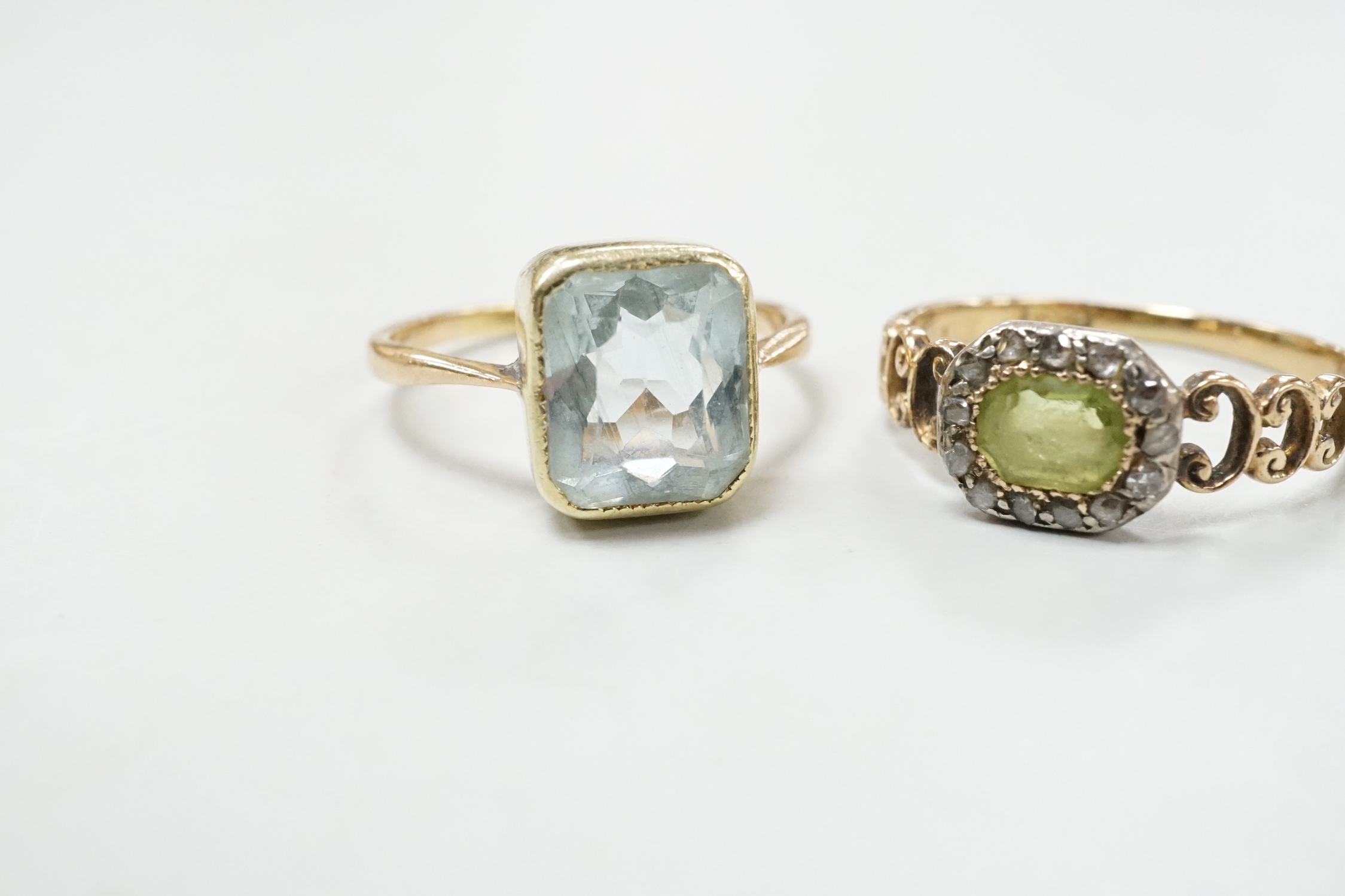 A late Victorian 15ct, peridot and diamond cluster set ring, size M and an Edwardian 15ct and aquamarine set ring, size K, gross weight 4.3 grams.